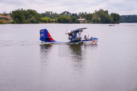 Photo for Aigueleze-Rivieres, France - July 2018 - Side view of a small biplane, equipped with two wings, floats, hull and propeller on the back, floating on the water after landing on the river Tarn - Royalty Free Image