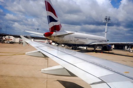 Téléchargez les photos : Paris, France - Juin 2019 - Un Boeing 767 bimoteur longue portée de la compagnie aérienne British Airways, vu depuis un Airbus A320 dont l'aile est visible, sur la piste de l'aéroport de Paris - en image libre de droit