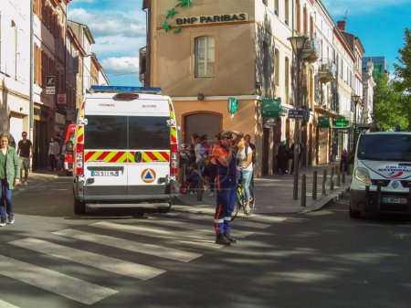 Photo for Albi, France - May 4, 2017 - Rescue trucks, police vehicle and first-aider of the Protection Civile securing the then candidate Emmanuel Macron's last election meeting before the second ballot - Royalty Free Image
