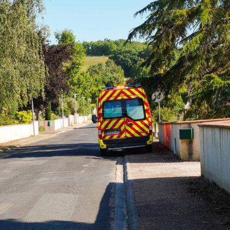 Téléchargez les photos : Le Sequestre, France - Mai 2020 - Un véhicule d'urgence rouge (Renault Master) des pompiers avec feux clignotants allumés et bandes réfléchissantes arrière stationnées sur le trottoir, lors d'une intervention de sauvetage - en image libre de droit
