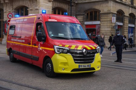 Foto de Reims, Francia - Marzo 2021 - Un vehículo de emergencia en movimiento; la ambulancia del cuerpo de bomberos y centro de rescate de Marne (SDIS), que tiene todas las luces encendidas, se precipita en una calle en una intervención - Imagen libre de derechos