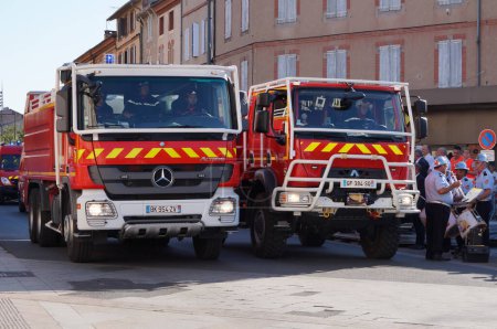 Photo for Albi, France - July 14, 2022 - Two red tank trucks for forest fire from the firefighting brigade of the Tarn (SDIS 81), take part to the National Day military parade on Charles de Gaulle Avenue - Royalty Free Image