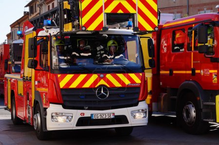 Foto de Albi, Francia - 14 de julio de 2022 - Dos camiones cisterna rojos para incendios forestales de la brigada de bomberos del Tarn (SDIS 81), participan en el desfile militar del Día Nacional en la avenida Charles de Gaulle - Imagen libre de derechos