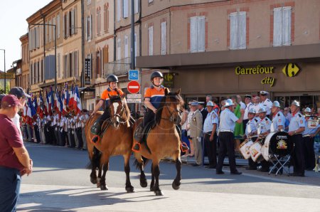 Foto de Albi, Francia - 14 de julio de 2023 - Chicas jóvenes, voluntarias de la organización de primeros auxilios Civil Protection (FNPC) montan a caballo en Charles de Gaulle Boulevard, en medio del desfile militar del Día Nacional - Imagen libre de derechos