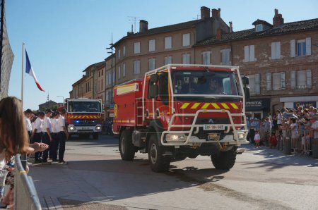 Photo for Albi, France - July 14, 2022 -  red, Mercedes-Benz truck from the fire brigade of the Tarn, equipped with a modern telescopic ladder, moving to join the National Day parade - Royalty Free Image