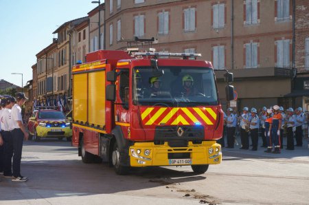 Foto de Albi, Francia - 14 de julio de 2022 - rojo, Mercedes-Benz camión de la brigada de bomberos del Tarn, equipado con una moderna escalera telescópica, se mueve para unirse al desfile del Día Nacional - Imagen libre de derechos