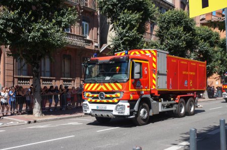Téléchargez les photos : Albi, France - 14 juillet 2022 - Camion Mercedes-Benz rouge de la brigade des pompiers du Tarn, équipé d'une échelle télescopique moderne, se déplaçant pour rejoindre le défilé de la fête nationale - en image libre de droit