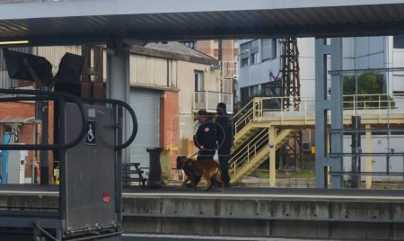 Foto de Toulouse, Francia - Nov. 2019 - Siluetas de guardias de seguridad con un perro policía de la policía ferroviaria privada de la compañía ferroviaria francesa SNCF, patrullando para la detección de explosivos y la aplicación de las drogas - Imagen libre de derechos