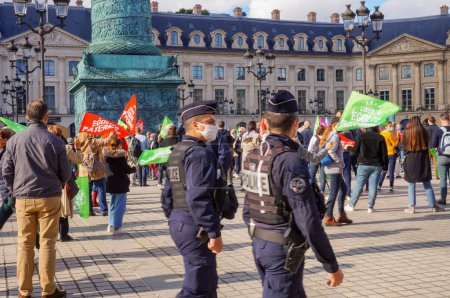 Photo for Paris, France - Oct. 10, 2020 - In the blur, armed police officers patrolling at Marchons Enfants' manifestation in defense of the family, in front of the Ministry of Justice, in Place Vendome - Royalty Free Image