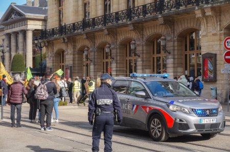 Téléchargez les photos : Reims, France - Mars 2021 - La toute nouvelle Peugeot 5008 de la Police Nationale, avec des feux clignotants bleus allumés, et une policière en intervention rue de Vesle lors d'une manifestation - en image libre de droit