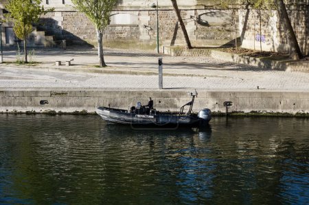 Téléchargez les photos : Paris, France - Avril 2021 - Un canot pneumatique de la Patrouille Bateau de la Préfecture de Police de Police sur la Seine, au bord de la jetée du quai de la Corse, sur le remblai de l'ile de la Cité - en image libre de droit