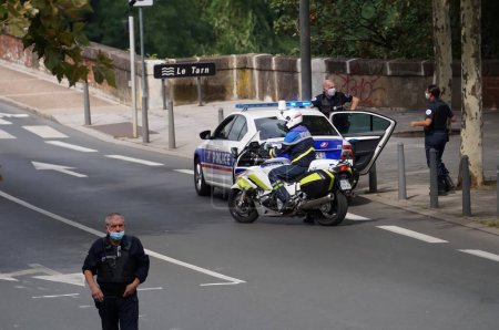 Téléchargez les photos : Albi, France - Sept. 2021 - Les policiers, à pied, en voiture et en moto à un barrage routier, contrôlent la circulation dans la rue lors d'une manifestation contre le col de la santé et les mesures Covid - en image libre de droit