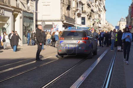 Téléchargez les photos : Reims, France - Février 2022 - Un VUS Peugeot 5008 gris et marqué de feux clignotants bleus de la police nationale accompagne une manifestation rue de Vesle, l'une des principales rues du centre-ville - en image libre de droit