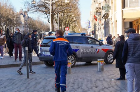 Téléchargez les photos : Reims, France - Février 2022 - Un VUS Peugeot 5008 gris et marqué de feux clignotants bleus de la police nationale accompagne une manifestation rue de Vesle, l'une des principales rues du centre-ville - en image libre de droit