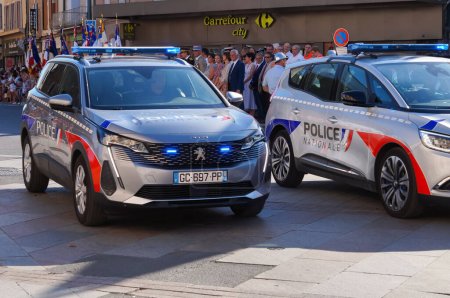 Photo for Reims, France - Feb. 2022 - A grey, marked Peugeot 5008 SUV of the National Police, with blue flashing lights on, escorts a demonstration on Rue de Vesle, one of the main streets in the city centre - Royalty Free Image