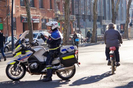 Photo for Toulouse, France - Feb. 2020 -  motorcyclists from a CRS unit of the French National Police, at a crosswalk in Jean Jaurs Square during a manifestation of Yellow Vests against the pension reform - Royalty Free Image