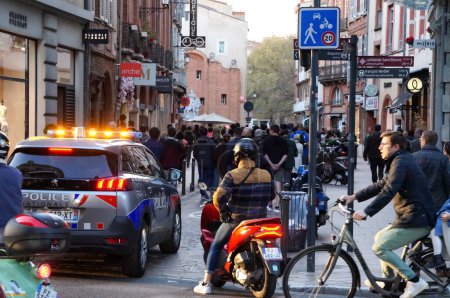 Foto de Toulouse, Francia - Marzo 2023 - Un vehículo de la Policía Nacional, todas las luces encendidas, sigue y escolta la parte posterior de una procesión católica en las calles, en celebración de la Anunciación, en el Día de la Señora - Imagen libre de derechos