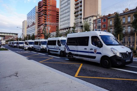 Foto de Toulouse, Francia - Ene. 2020 - Tráfico de automóviles y caravanas de minibuses Renaul Master de las unidades antidisturbios de la Policía Nacional Francesa (CRS) en un semáforo en Strasbourg Boulevard durante las protestas sociales - Imagen libre de derechos