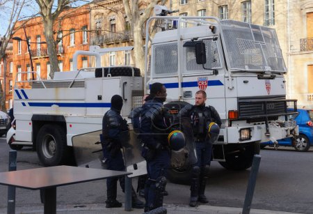 Téléchargez les photos : Toulouse, France - Jan. 2020- Des officiers français du SWAT (CRS) en tenue anti-émeute, armés d'une lourde armure, d'un casque et d'un lance-grenades, montent dans des minibus à la fin d'une opération de police lors d'une manifestation - en image libre de droit