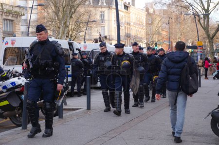 Téléchargez les photos : Toulouse, France - Jan. 2020- Des officiers français du SWAT (CRS) en tenue anti-émeute, armés d'une lourde armure, d'un casque et d'un lance-grenades, montent dans des minibus à la fin d'une opération de police lors d'une manifestation - en image libre de droit