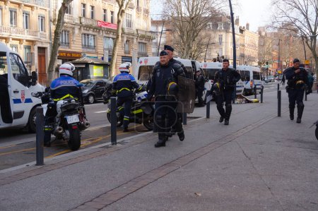 Photo for Toulouse, France -Jan. 2020- French SWAT officers (CRS) in riot gear, having heavy body armor, helmet and grenade launcher, getting on minibuses at the end of a police operation at a demonstration - Royalty Free Image