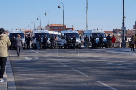 Téléchargez les photos : Toulouse, France - Février 2023 - Un cordon de police formé de camionnettes et d'agents anti-émeutes équipés d'armures et de boucliers bloque l'accès au Pont-Neuf, au milieu des protestations contre la réforme des retraites - en image libre de droit