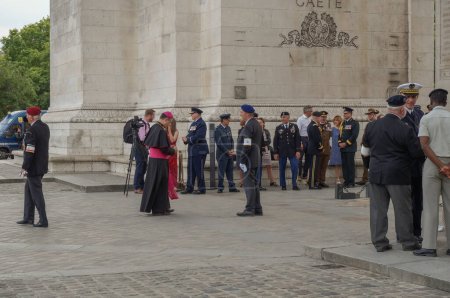 Photo for Paris, France - July 2019 - French and foreign officers, officials, war veterans and military ordinary in a ceremony below Arc de Triomphe, under the surveillance of a soldier of the French Army - Royalty Free Image