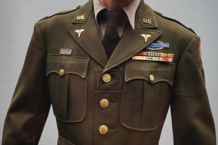 Foto de Reims, Francia - Sept. 2022 - Un uniforme de oficial del Ejército de los Estados Unidos de la Segunda Guerra Mundial, con condecoraciones militares, exhibido en el Museo de la Rendición Alemana (Musee de la Reddition), donde los nazis capitularon - Imagen libre de derechos
