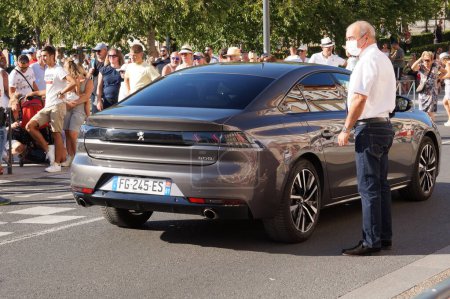 Photo for Albi, France - July 14, 2021 - The Prefecture's driver waits for the Prefect by his official car, a dark grey French Peugeot 508, at the end of the National Day ceremony, on Charles de Gaulle Avenue - Royalty Free Image