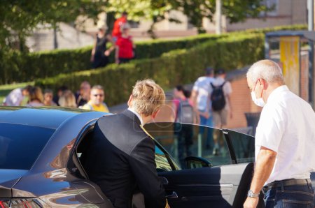 Téléchargez les photos : Albi, France - 14 juillet 2022 - Le préfet du Tarn, Franois-Xavier Lauch, monte dans la voiture officielle Peugeot 508 de la préfecture, à l'issue de la cérémonie de la fête nationale, aidé d'un chauffeur - en image libre de droit