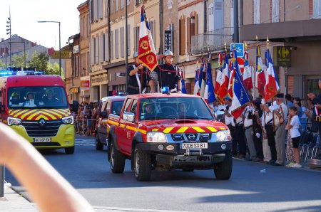 Foto de Albi, Francia - 14 de julio de 2022 - Bomberos del servicio de bomberos y rescate del Tarn, desfilan en sus vehículos rojos con su estandarte, saludando a las autoridades, para las celebraciones del Día Nacional - Imagen libre de derechos