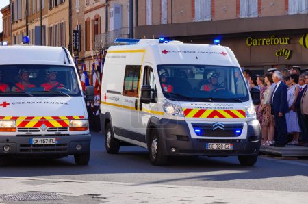 Foto de Albi, Francia - 14 de julio de 2022 - Dos furgonetas Renault Sprinter blancas, vehículos de emergencia, de la Cruz Roja Francesa ("Croix-Rouge franaise"), desfilando por la calle en medio de las celebraciones del Día Nacional - Imagen libre de derechos