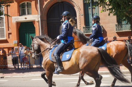 Photo for Toulouse, France - July 14, 2023 - Young female officers with a mounted unit of the National Police, riding horses on Ozenne Street amid the military parade held on National Day ("Bastille Day") - Royalty Free Image