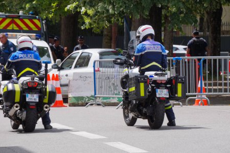 Foto de Toulouse, Francia - 8 de mayo de 2023 - Dos oficiales de la Policía Nacional en motocicletas escoltan el automóvil del Prefecto a través del control de carreteras establecido para filtrar el acceso a la ceremonia militar del Día de la Victoria. - Imagen libre de derechos
