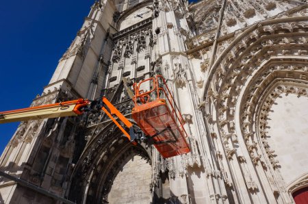 Photo for Troyes, France - Sept. 2020 - An aerial work platform in front of Saint-Pierre-et-Saint-Paul's Cathedral, amid works of Christian heritage protection performed on the facade of the gothic landmark - Royalty Free Image