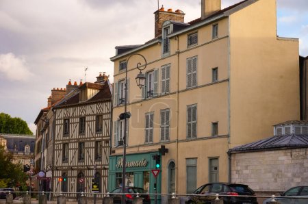 Foto de Troyes, Francia - Sept. 2020 - Un antiguo edificio tradicional que alberga Bailly Pharmacy, y una casa de entramado de madera en Quai Dampierre, junto a la barandilla del Canal de Trvois en el centro histórico de la ciudad - Imagen libre de derechos
