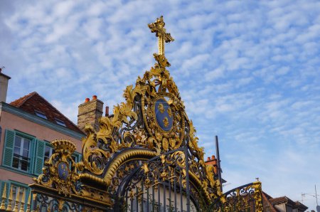 Photo for Troyes, France - Sept. 2020 - The richly crafted gate of the Hotel-Dieu-Le-Comte, the Counts of Troyes' 18th century lordly mansion, featuring a gilded coat of arms topped by a golden catholic cross - Royalty Free Image