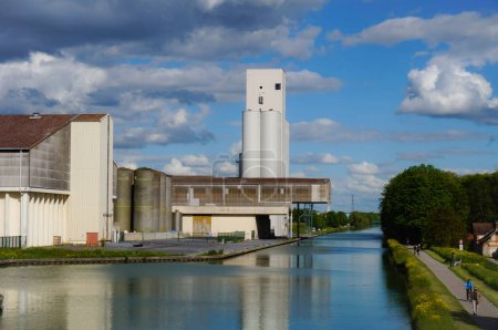 Foto de Reims, Francia - Mayo 2021 - Almacenamiento de granos y plantas industriales en el puerto fluvial de Pre des Moines Quay, junto al canal Marne-Aisne, en la región de Champagne, que alberga una poderosa industria agroalimentaria - Imagen libre de derechos