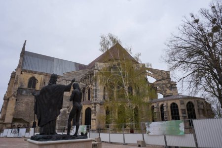 Foto de Reims, Francia - Abril 2021 - Frente al ábside de la basílica medieval de Saint-Remi, una estatua de bronce de 1996 conmemora el bautismo de Clovis, rey de los francos, por el obispo Saint-Remi en 496 - Imagen libre de derechos