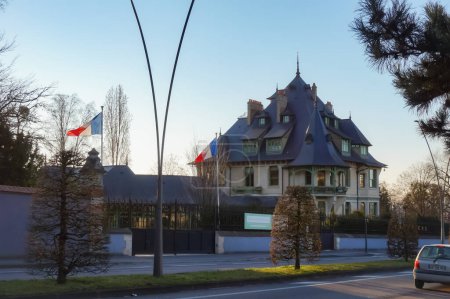 Foto de Reims, Francia - Marzo 2021 - Banderas francesas en la entrada de la Villa Demoiselle, una mansión del siglo XIX que pertenece a la finca vinícola del prestigioso productor francés de champán Vranken-Pommery - Imagen libre de derechos