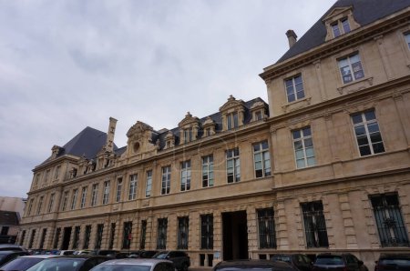 Photo for Reims, France - April 2021 - Cars parked on the street of Rue de la Grosse critoire, at the foot of the back facade of the City Hall, an edifice built in the 17th century in French classical style - Royalty Free Image