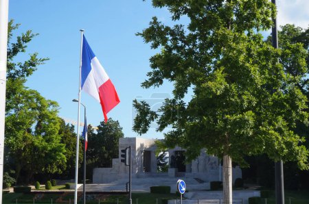 Foto de Reims, Francia - Mayo 2022 - Bandera de Francia junto al monumento de piedra a los muertos del memorial de guerra de Reims, erigido para ambas guerras mundiales, en la Plaza de Reims, frente a la Plaza de la República - Imagen libre de derechos