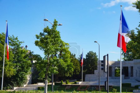 Téléchargez les photos : Reims, France - Mai 2022 - Drapeau de la France par le monument en pierre aux morts du Mémorial de guerre de Reims, érigé pour les deux guerres mondiales, sur la place de Reims, en face de la place de la République - en image libre de droit