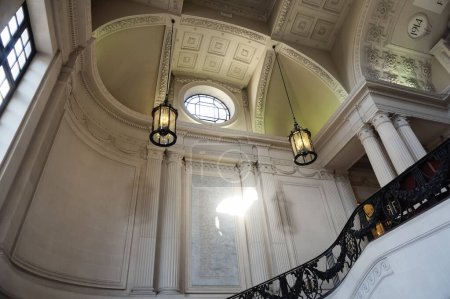 Foto de Reims, Francia - Sept. 2022 - Chandeliers colgando del techo trabajado dentro del Ayuntamiento, en la Gran Escalera, que tiene un óculo, una placa conmemorativa y columnas de estilo neo Luis XIII - Imagen libre de derechos