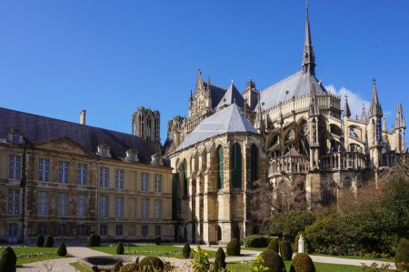 Photo for Reims, France - March 2021 - Apse of Notre-Dame Cathedral, a UNESCO World Heritage Site, seen from the French-style garden of the 17th century Palace of the Tau, formerly an episcopal residence - Royalty Free Image