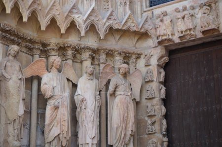 Foto de Estatua rica, esculpida en el siglo XIII, de la Catedral de Notre-Dame de Reims, en Francia, junto al portal de entrada, con el famoso "Ángel Sonriente" (alias "La Sonrisa de Reims")") - Imagen libre de derechos