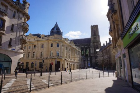 Foto de Reims, Francia - Marzo 2021 - Un edificio abovedado del siglo XX en la esquina de las calles de Cours Langlet, Rue Carnot y Rue du Trsor; a lo lejos, la torre de la catedral gótica de Notre-Dame - Imagen libre de derechos