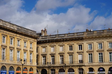 Foto de Reims, Francia - Marzo 2021 - Adosados de estilo clásico, con balaustres de piedra en el techo y arcos en la planta baja, construidos en el siglo XVIII en la Place Royale, en el centro histórico de la ciudad - Imagen libre de derechos