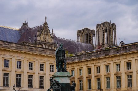 Téléchargez les photos : Statue en bronze du roi Louis XV sur la place Royale à Reims, en face du bâtiment classique du XVIIIe siècle de la sous-préfecture ; derrière, la cathédrale gothique Notre-Dame - en image libre de droit