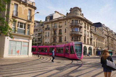 Téléchargez les photos : Reims, France - Juin 2021 - Un train léger Citura Alstom rose tourne au coin des rues de la Rue de Vesle, du Cours Jean-Baptiste Lenglet et de la Rue Carnot, dans le centre historique de la ville - en image libre de droit